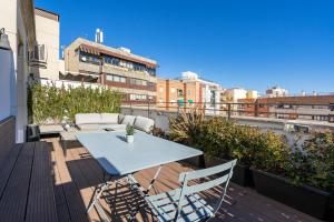 um pátio com uma mesa e cadeiras numa varanda em Feelathome Waldorf Suites Apartments em Madrid