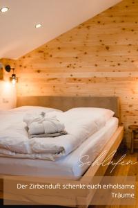 a bed in a room with a wooden wall at Zirben -Chalet 2 in Winkl Heiligenblut