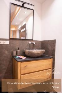 a bathroom with a sink and a mirror at Zirben -Chalet 2 in Winkl Heiligenblut