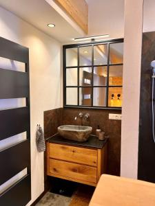 een badkamer met een wastafel en een spiegel bij Zirben -Chalet 2 in Winkl Heiligenblut