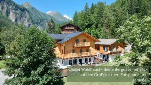 a large wooden house in the middle of a mountain at Zirben -Chalet 2 in Winkl Heiligenblut