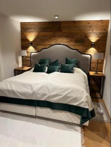 a bedroom with a large bed with green pillows at Spa, Sport & City Luxury Ski-in Ski-Out Apartment in Kitzbühel