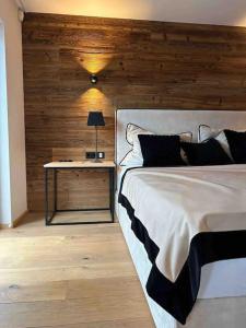 a bedroom with a bed and a table with a lamp at Spa, Sport & City Luxury Ski-in Ski-Out Apartment in Kitzbühel