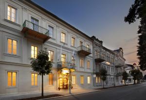 a large white building on the side of a street at Badenia Hotel Praha in Františkovy Lázně