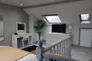 1 dormitorio con 1 cama, TV y escritorio en Relax & Unwind In A Stunning 3BD Home in Sheffield en Sheffield