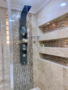 baño con ducha y puerta de cristal en GLOVIS LUXURY APARTMENT, en Abuja