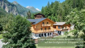 a large wooden house in the middle of a mountain at Zirben -Chalet 1 in Winkl Heiligenblut