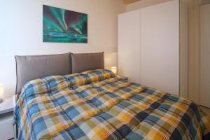 a bedroom with a bed with a plaid blanket at HouseImperia in Imperia