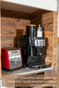 a coffee maker and a toaster on a shelf at Zirben -Chalet 1 in Winkl Heiligenblut