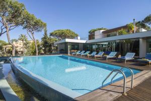 a swimming pool in front of a house at Villa Golf in Vilamoura