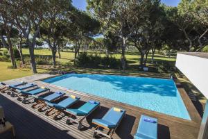 uma piscina com espreguiçadeiras e uma piscina em Villa Golf em Vilamoura