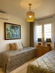 a bedroom with two beds and a chandelier at Panoramic Seaview in Mijas