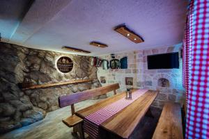 Zimmer mit einem Holztisch und einer Steinmauer in der Unterkunft Apartman M&S s bazenom in Podstrana