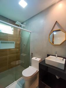 a bathroom with a toilet and a sink and a shower at Flats Marina Maragogi in Maragogi
