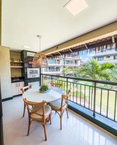 a dining room with a table and chairs and a balcony at Manhattan Beach Riviera Aquiraz in Aquiraz +2 photos