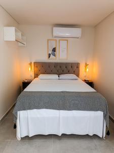 een slaapkamer met een groot bed met twee lampen aan beide zijden bij Flats Marina Maragogi in Maragogi