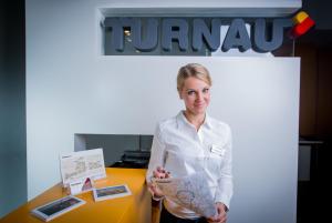a woman standing in front of a table holding a map at Turnau City Aparthotel in Krakow