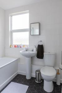 Baño blanco con aseo y lavamanos en Large two bedroom Apartment in Cliftonville, en Kent