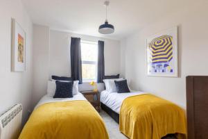 2 camas en una habitación con mantas amarillas en Large two bedroom Apartment in Cliftonville, en Kent