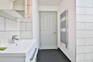 a white bathroom with a sink and a door at April Disc - Long Stay - Contractors in Bristol