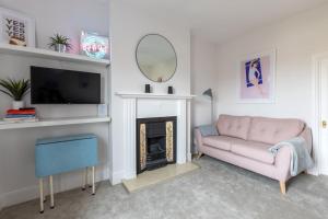 sala de estar con sofá rosa y chimenea en Large two bedroom Apartment in Cliftonville, en Kent