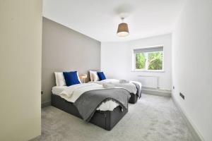 a white bedroom with two beds and a window at April Disc - Long Stay - Contractors in Bristol