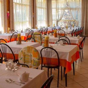 een eetkamer met tafels en stoelen met witte tafelkleden bij HOTEL ITALIACERVIA Free Breakfast in Cervia