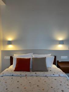 a bed with two pillows on it with two lights at Αργουλιάς in Tzermiádon