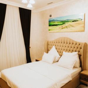 a bedroom with a bed with white sheets and pillows at Reikartz Namangan in Namangan