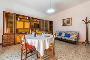 ein Esszimmer mit einem Tisch und einem Sofa in der Unterkunft Domo de Maria - Calamenhir in SantʼAntìoco