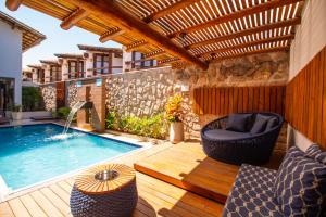 a patio with a swimming pool and a wooden deck at Hotel Bem Brasil in Porto Seguro