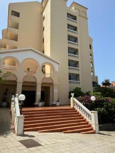 un grand bâtiment avec des escaliers en face d'un bâtiment dans l'établissement Apartamento Castle Harbour, à Los Cristianos