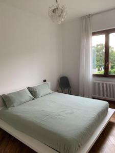 Schlafzimmer mit einem weißen Bett und einem Kronleuchter in der Unterkunft La finestra sul lago di Como in Como