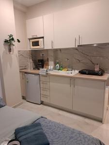 a small kitchen with a sink and a microwave at Domenica studios 1 in Thessaloniki