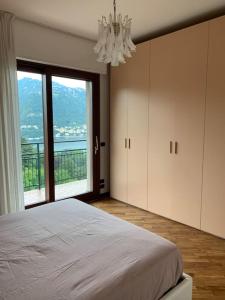 ein Schlafzimmer mit einem Bett und einem großen Fenster in der Unterkunft La finestra sul lago di Como in Como