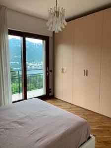 a bedroom with a bed and a large window at La finestra sul lago di Como in Como