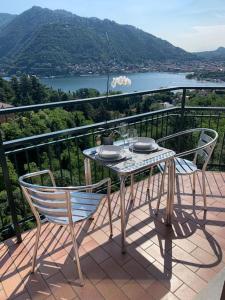 a table and chairs on a balcony with a view at La finestra sul lago di Como in Como