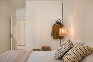 a white bedroom with a bed and a lamp at Mystique Lagoon Villa in Argostoli