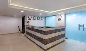 a waiting room with clocks on the wall at Treebo Trend Cordial Home - Jasola in New Delhi