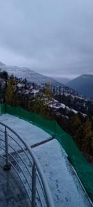 斯瓦特的住宿－Ihram Hotel And Guest House，雪覆盖的山顶上的绿色围栏