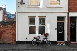 a bike parked in front of a white house at Boujee & chic city centre house in Oxford