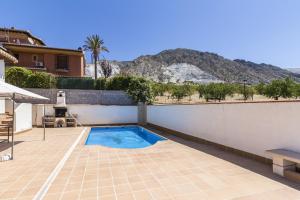 een zwembad in het midden van een patio met een huis bij Casa Vistas del Valle in Dúrcal