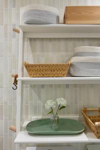 a shelf with a green plate with a vase of flowers at Boujee & chic city centre house in Oxford