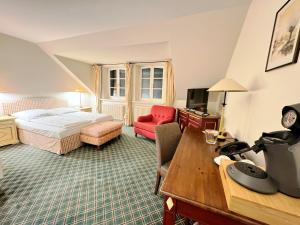 una camera d'albergo con un letto e una scrivania di Schloss Lüdersburg Golf & Spa a Lüdersburg Altre 105 foto