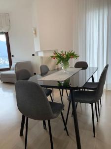 a dining room table with chairs and a vase of flowers on it at La finestra sul lago di Como in Como