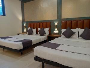 a bedroom with two beds and two lamps in it at TRI HOTEL in Mumbai