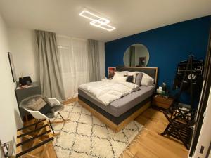 een slaapkamer met een bed en een blauwe muur bij Piz Alpina die grosse, moderne Wohnung mit Bergsicht in Davos