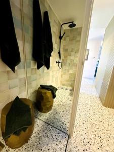 a bathroom with a shower stall and a mirror at Gatsby Apartment@Mackay 