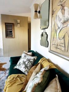 a living room with a green couch with pillows at Gatsby Apartment@Mackay 