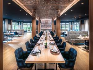 uma grande sala de jantar com uma mesa longa e cadeiras em Steigenberger Hotel Treudelberg Hamburg em Hamburgo